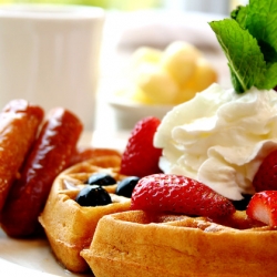 Blueberry waffles with strawberries and sausages